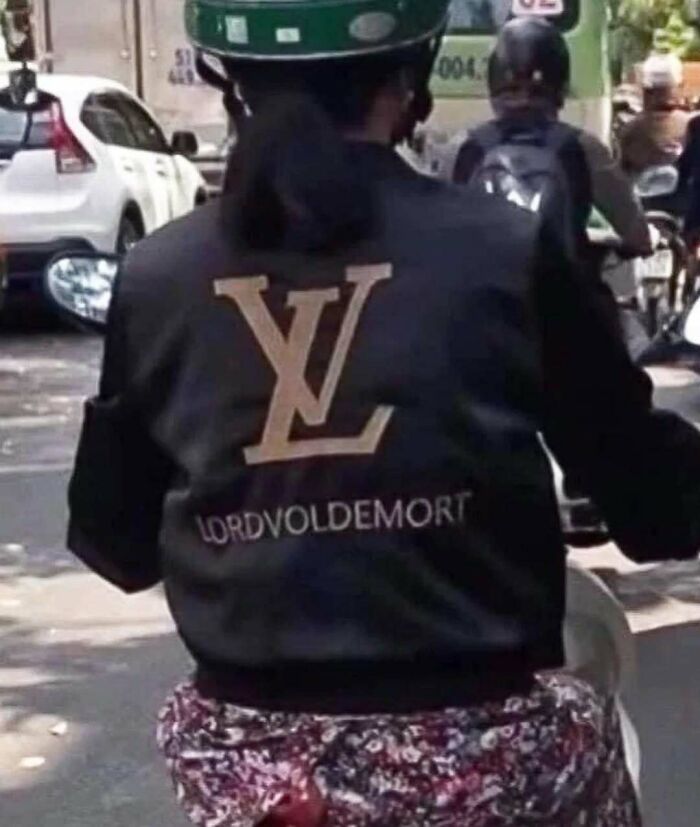 Biker with jacket humorously displaying "Lordvoldemort" text, combining luxury brand initials in an unexpected translation twist.