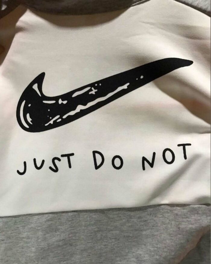 T-shirt with a swoosh logo and "Just Do Not" text, humorously lost in translation.