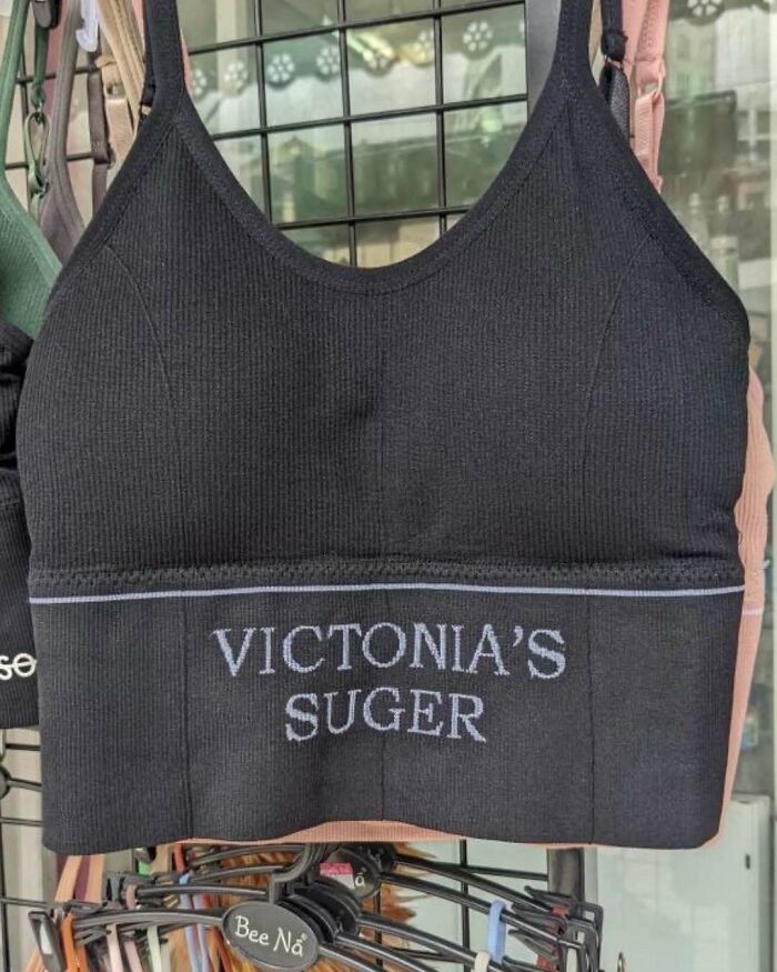 Black tank top with text "VICTONIA'S SUGER." Hilarious translation error on clothing.