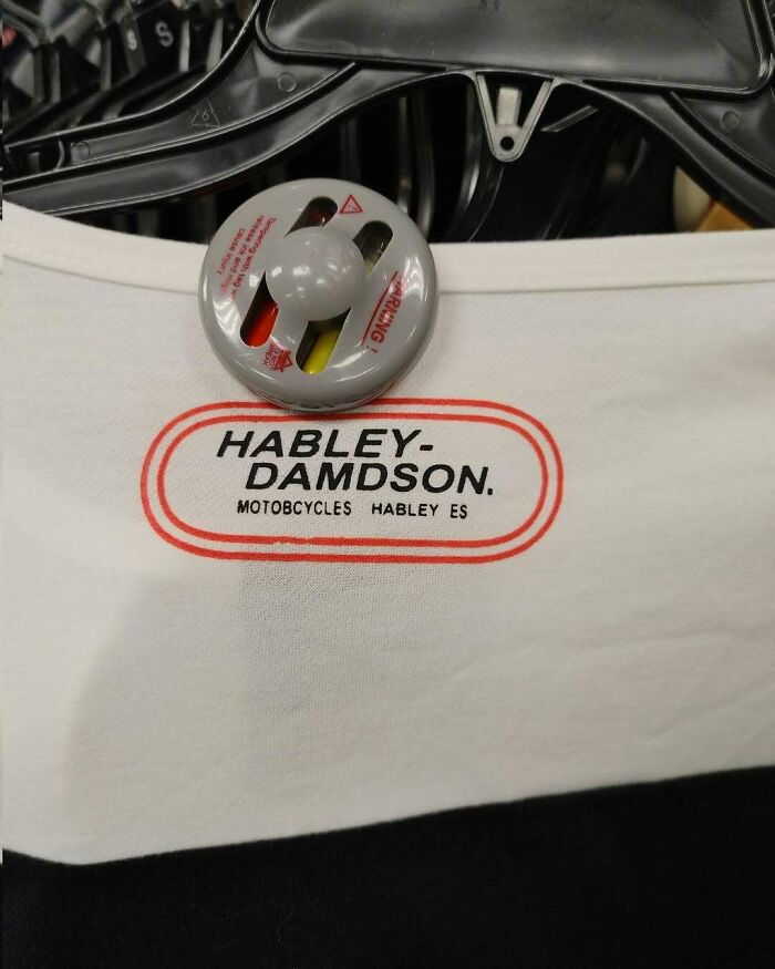 T-shirt with "Habley-Damdson" logo humorously lost in translation, hanging on a rack with a security tag.
