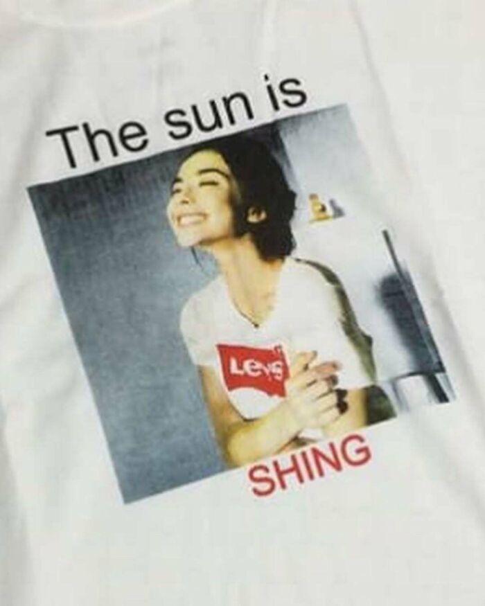 T-shirt with a humorous translation error: "The sun is shing" beneath a smiling person.