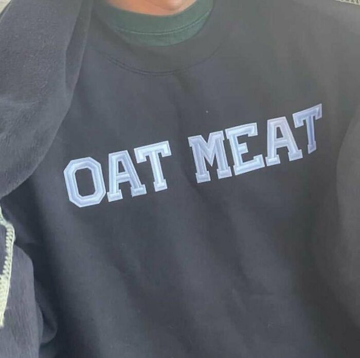 Black shirt with white letters humorously reading "OAT MEAT" instead of "OATMEAL."