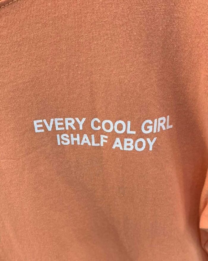 Orange T-shirt with funny misprint: "Every Cool Girl Is Half A Boy."