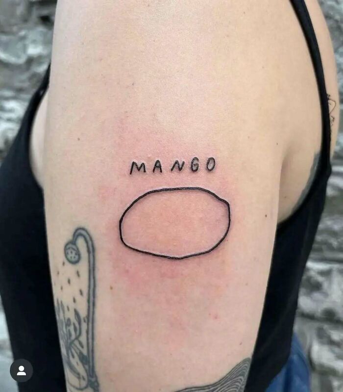Bad tattoo on arm labeled "Mango" with an oval shape, featured in Body Art Museum.