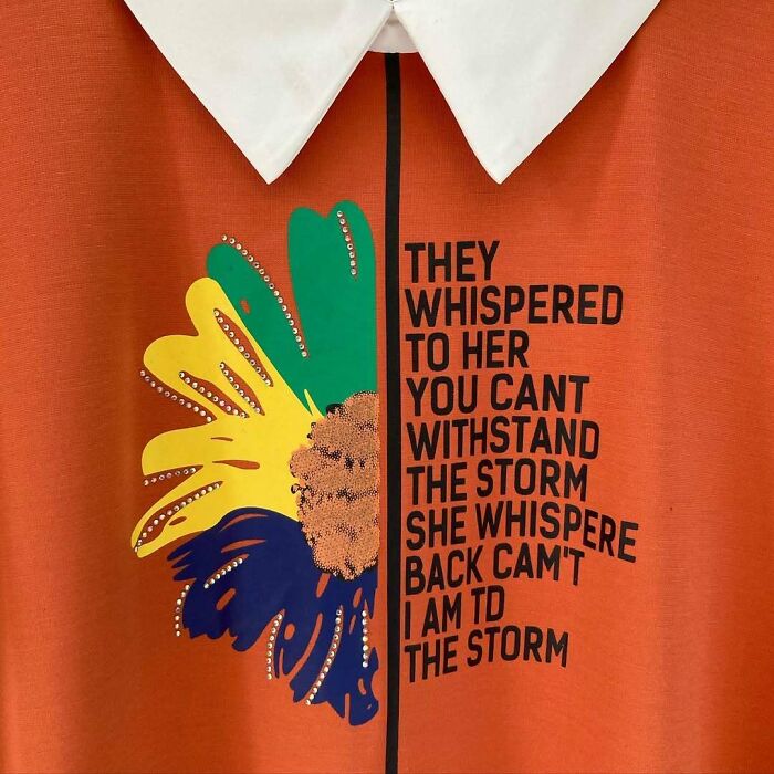 Orange T-shirt with a floral design, featuring hilariously mistranslated motivational text.