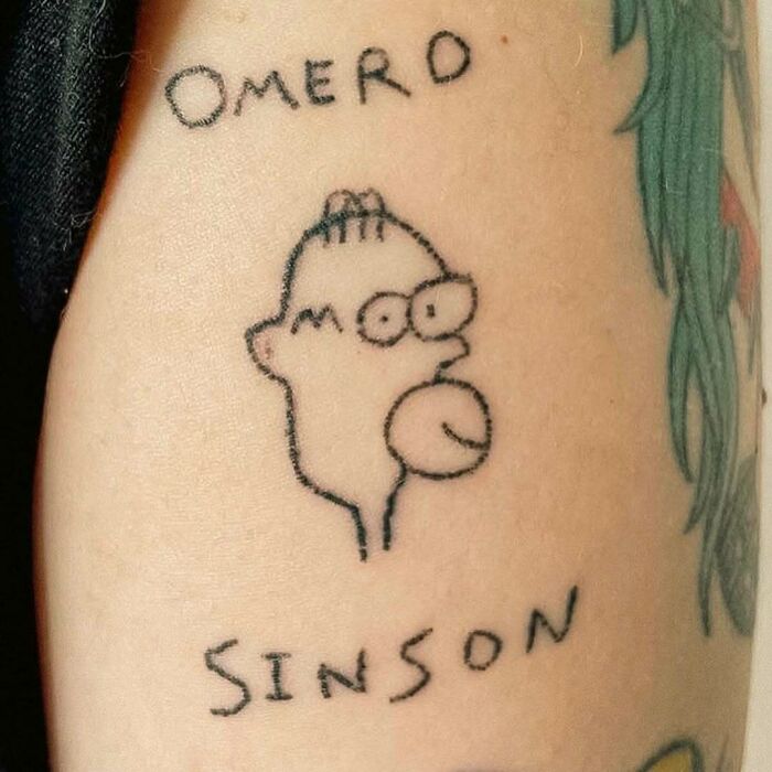 Minimalist Simpsons tattoo with misspelled text reading "Omard Sinson" on skin.