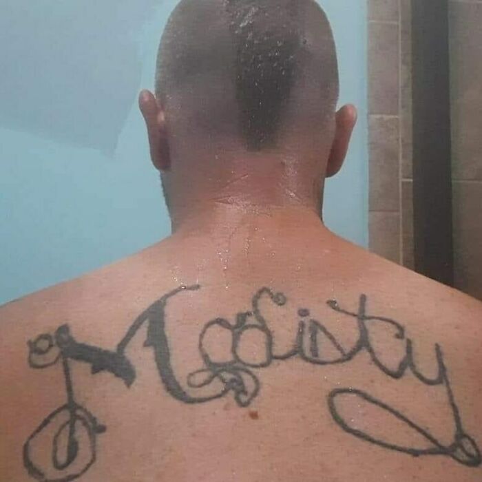 Person with a misspelled back tattoo, an example of permanent ink mistakes.