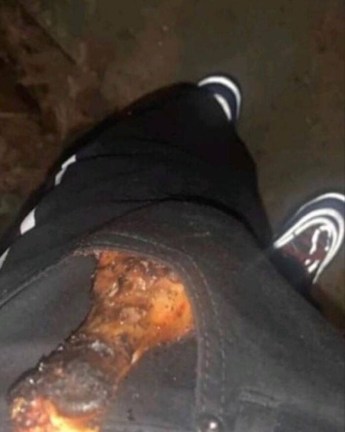 Person humorously placing chicken leg in pocket, wearing dark pants and sneakers, reflecting funny posts theme.