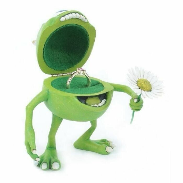 Green character ring holder with open mouth, holding a daisy. One of the best posts from a popular IG page.