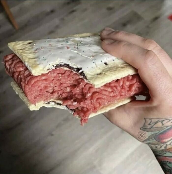 A hand holds a Pop-Tart with raw ground meat filling, showcasing unusual food creativity from an IG page.
