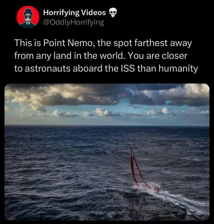 Sailboat at Point Nemo, the remote ocean spot farthest from land, under a vast and cloudy sky.