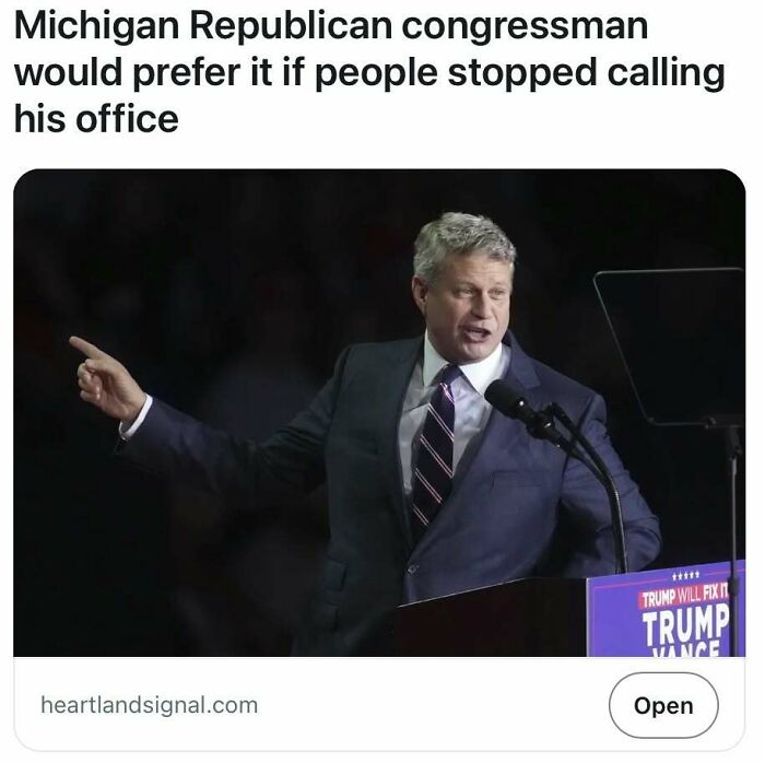 Man at podium gestures while speaking about a controversial call center raid.