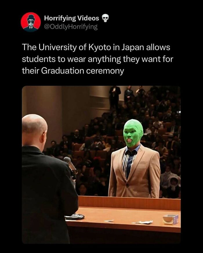 Student in a green mask and tan suit at a Kyoto University graduation, creating an oddly horrifying scene.