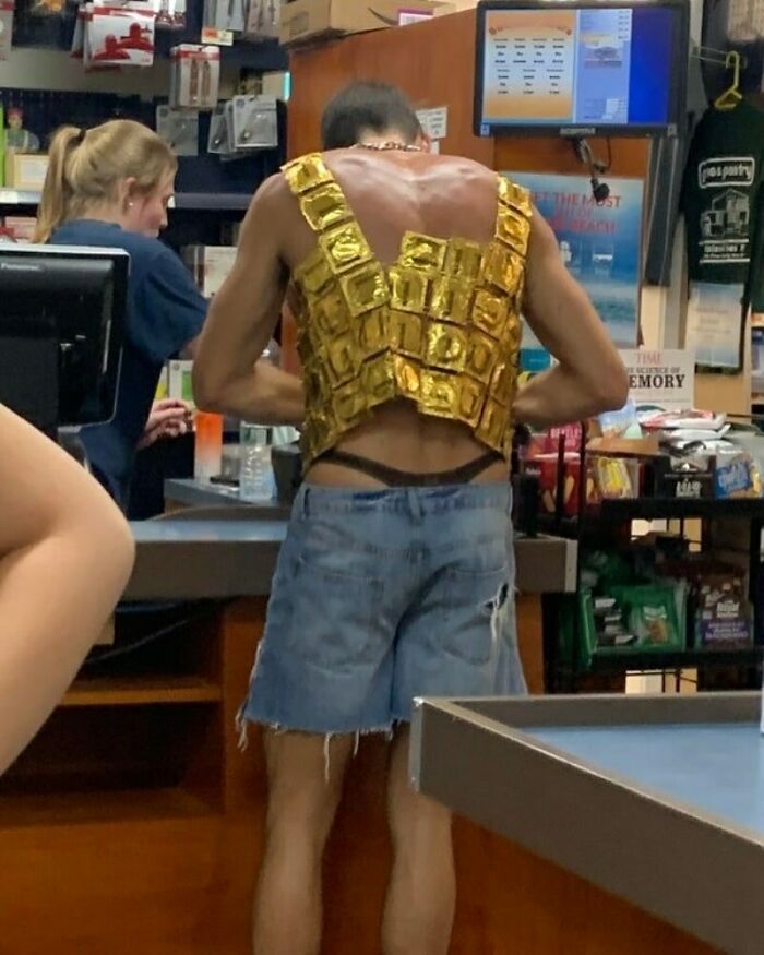 Man wearing a vest made of gold wrappers at a store counter, featuring humor and creativity from hardest posts on IG.