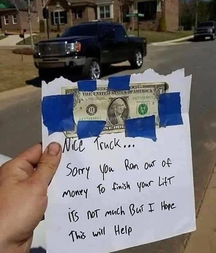 Hand holding a note with a dollar bill taped, humorously commenting on a lifted truck. Car memes theme.