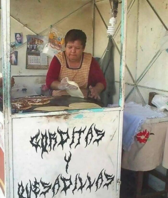 Woman cooking at a street food stall with unusual font on the sign, illustrating random cursed images.