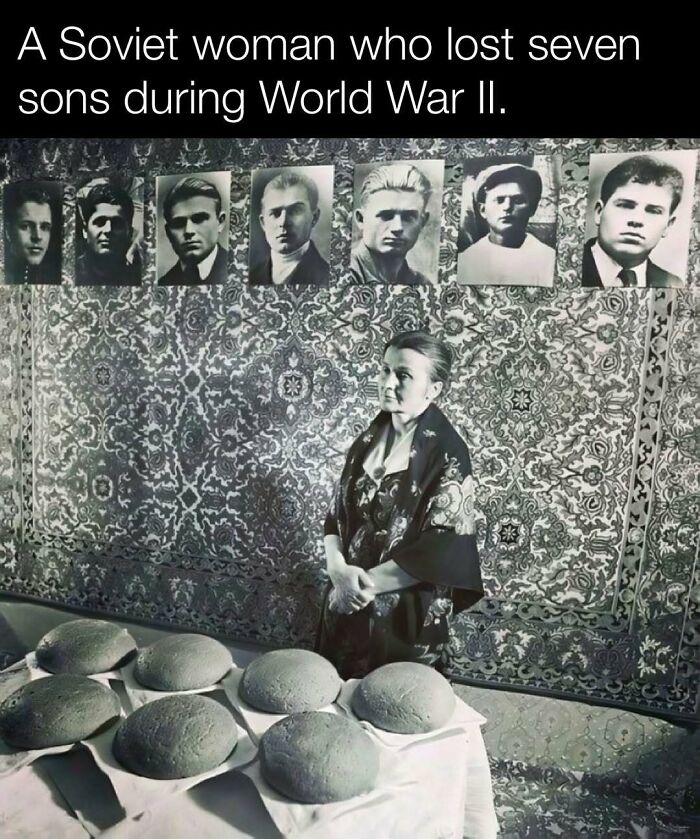 Soviet woman during WWII, mourning seven sons, standing by bread loaves, with their photos on a patterned wall backdrop.