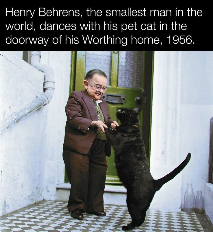 Smallest man dances with pet cat in 1956, Worthing home, capturing a charming historical moment.
