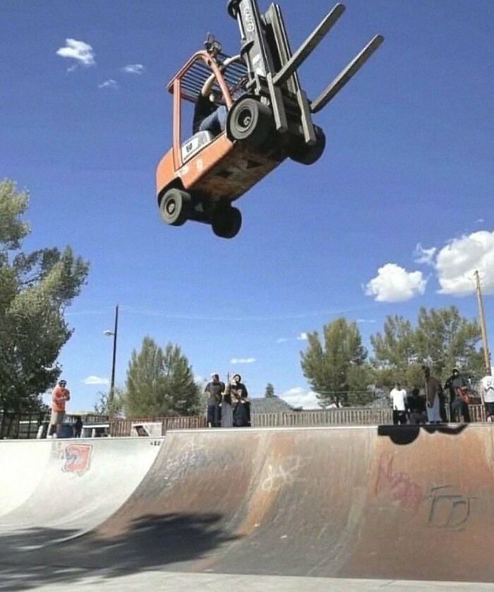 Forklift airborne over a skate park, capturing literally the hardest posts moment against a clear sky.
