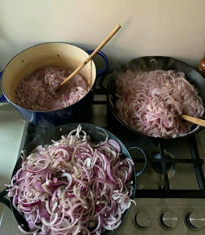 Three pots on a stove filled with sliced onions, highlighting an extreme cooking challenge.