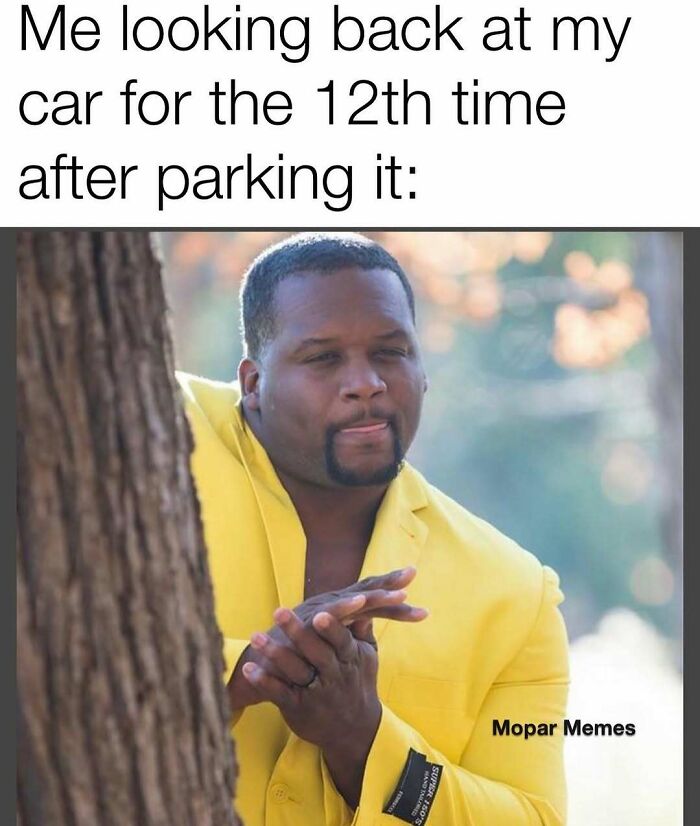 Man in yellow jacket humorously looking at car; car memes for mood lift.