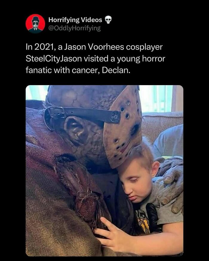Jason Voorhees cosplayer embraces young fan, creating an oddly horrifying yet touching moment on a couch.