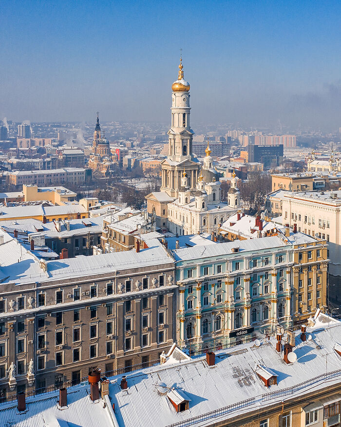 Aerial view of snow-covered city buildings and historic church towers showcasing the world from a new perspective.