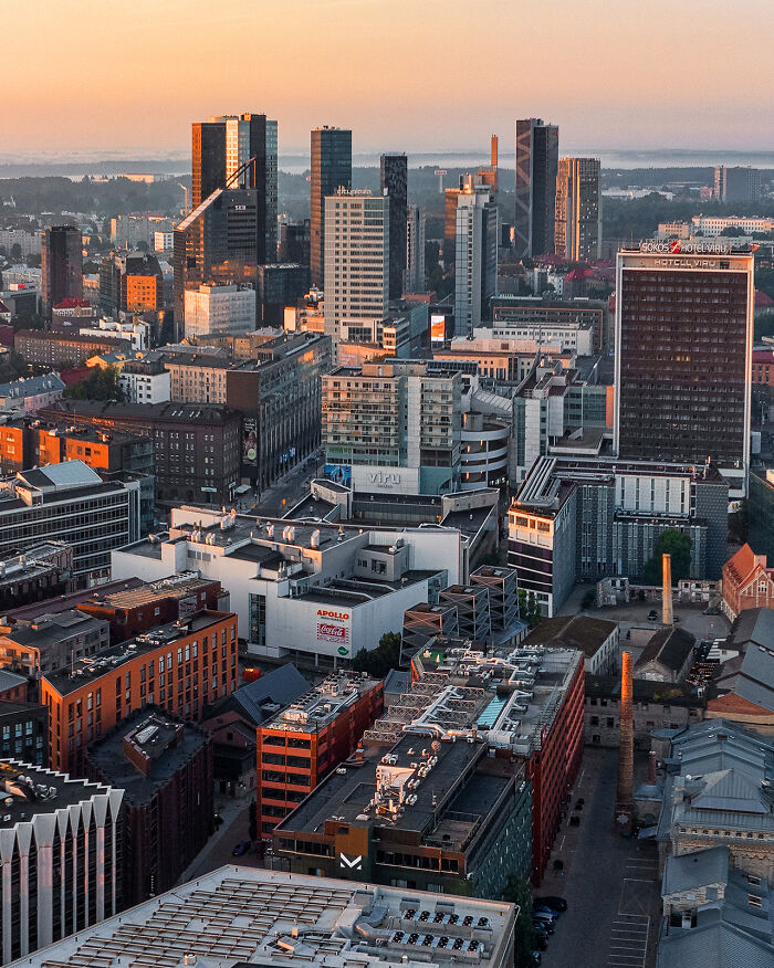 Aerial cityscape at sunset featuring modern skyscrapers and urban buildings showcasing the world from a new perspective.
