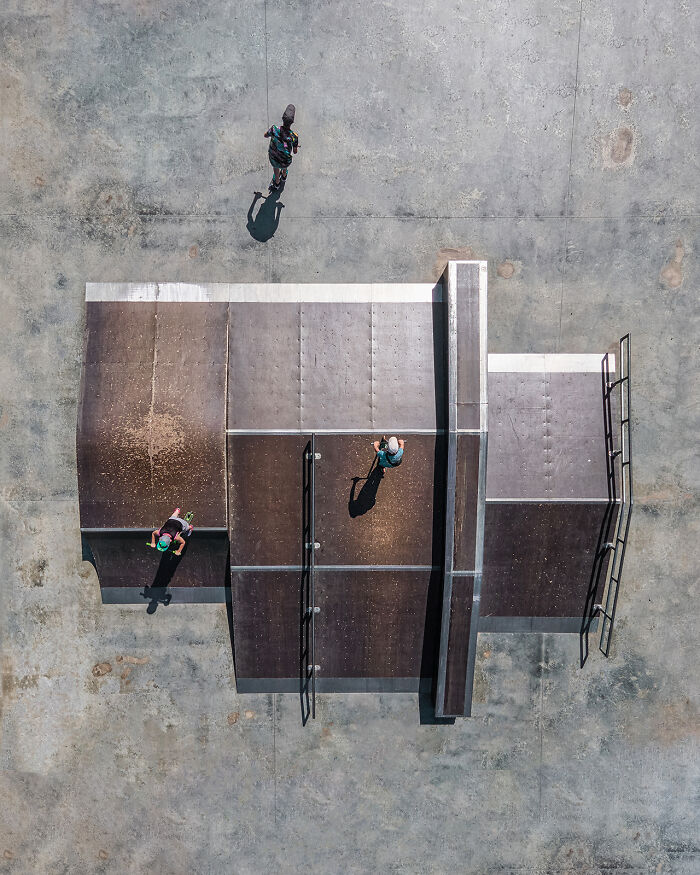 Aerial image capturing skateboarders at a skate park showcasing the world from a whole new perspective.