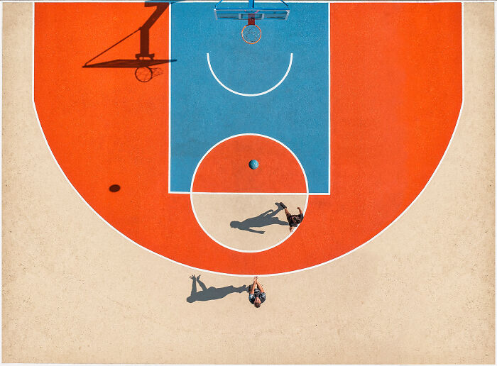 Aerial image of two people playing basketball on a vibrant court, showcasing the world from a new perspective.