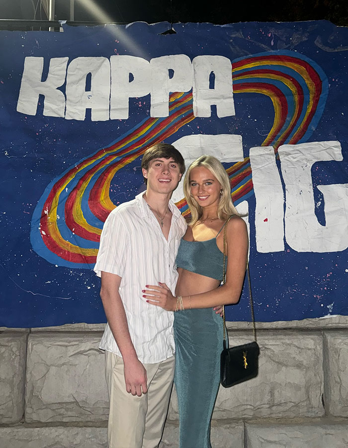 Young couple posing in front of a "Kappa" sign outside, related to Dave Portnoy rumor apology.