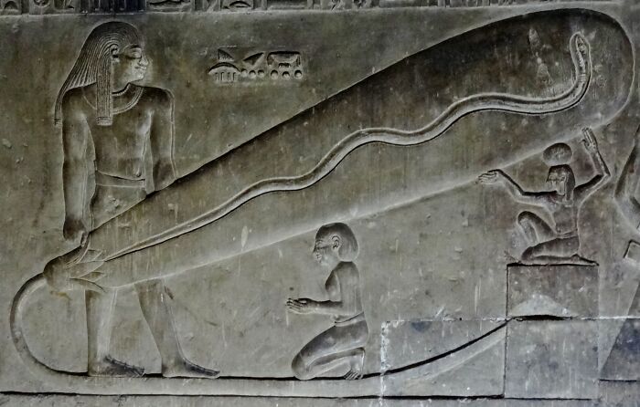 Ancient artifact carving depicting figures with a large, mysterious object, intriguing modern scientists.