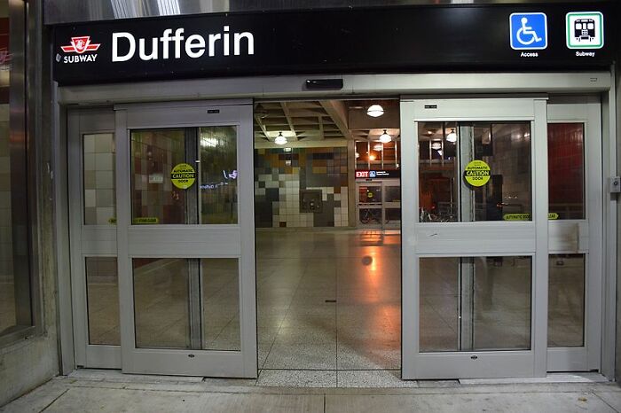 Entrance to Dufferin Subway Station with accessible signage at night.