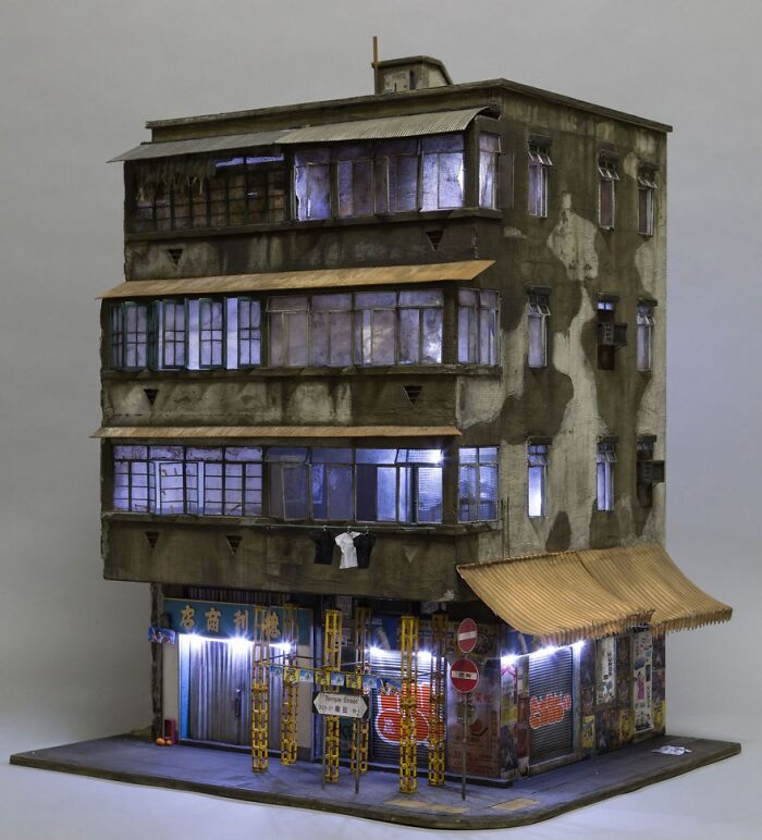 Miniature of a detailed, weathered urban building with illuminated windows, showcasing a secret world.