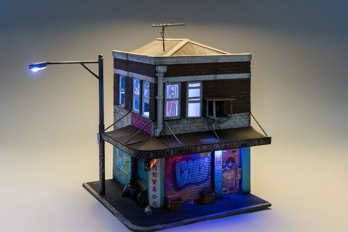 Miniature building model with detailed street scene, showcasing a secret world under a glowing streetlight.