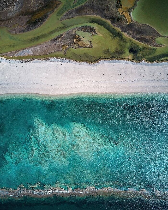 Aerial drone photo by Dimitar Karanikolov of a vibrant shoreline with turquoise waters and green landscapes.