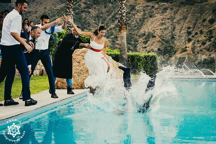 Bride and groom plunge into a pool, surrounded by cheering guests at the 2025 Premios FDB Awards.
