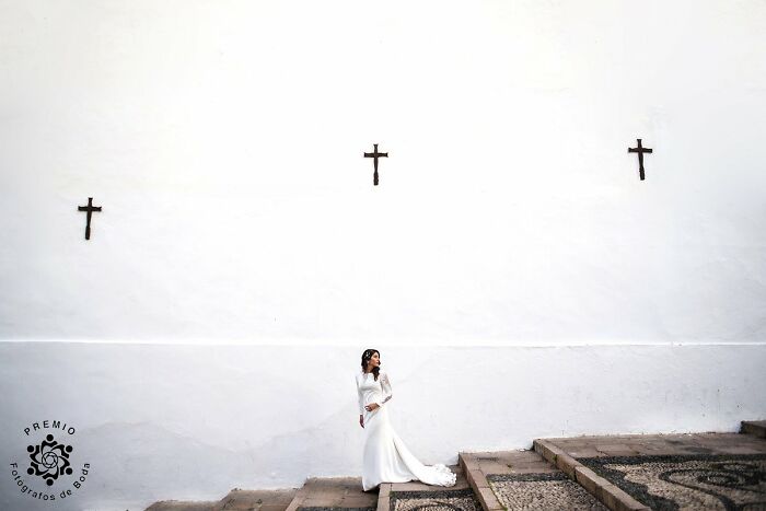 Bride in white dress on stone steps, featured in top wedding photos at the 2025 Premios FDB Awards.