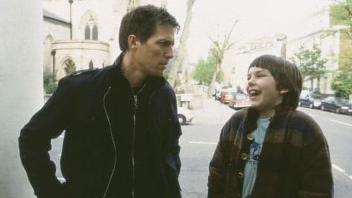 Man and child laughing outdoors on a street near trees and buildings. Man and child laughing outdoors on a street near trees and buildings.