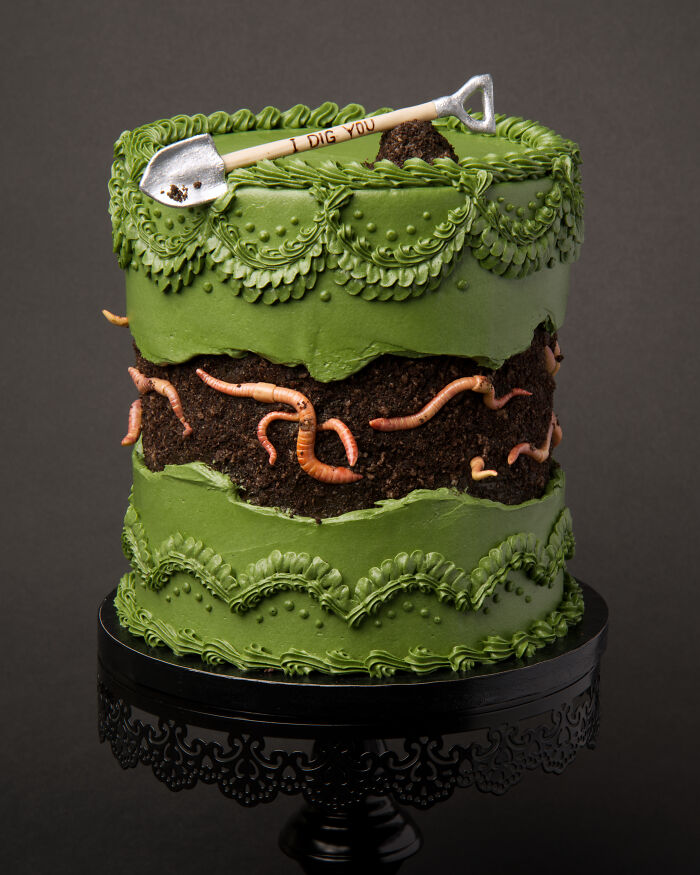 Vegan cake decorated with edible worms, green frosting, and a shovel topper, themed with bugs and slugs.