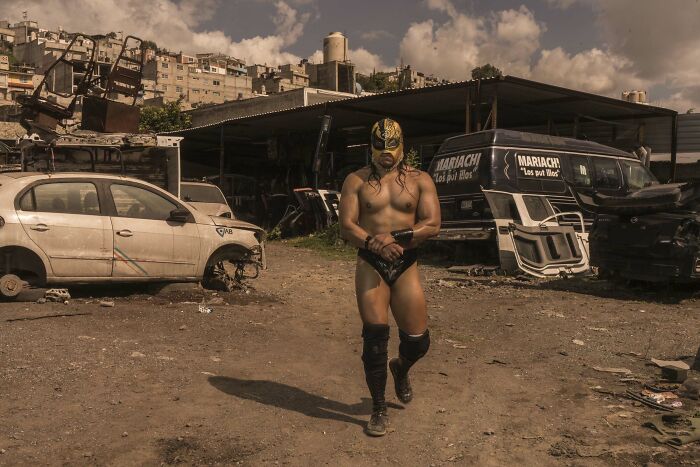 Masked wrestler in a scrapyard setting, capturing the essence of Istanbul Photo Awards 2025.