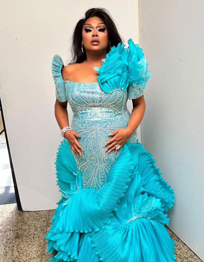 Jiggly Caliente in an ornate turquoise gown.