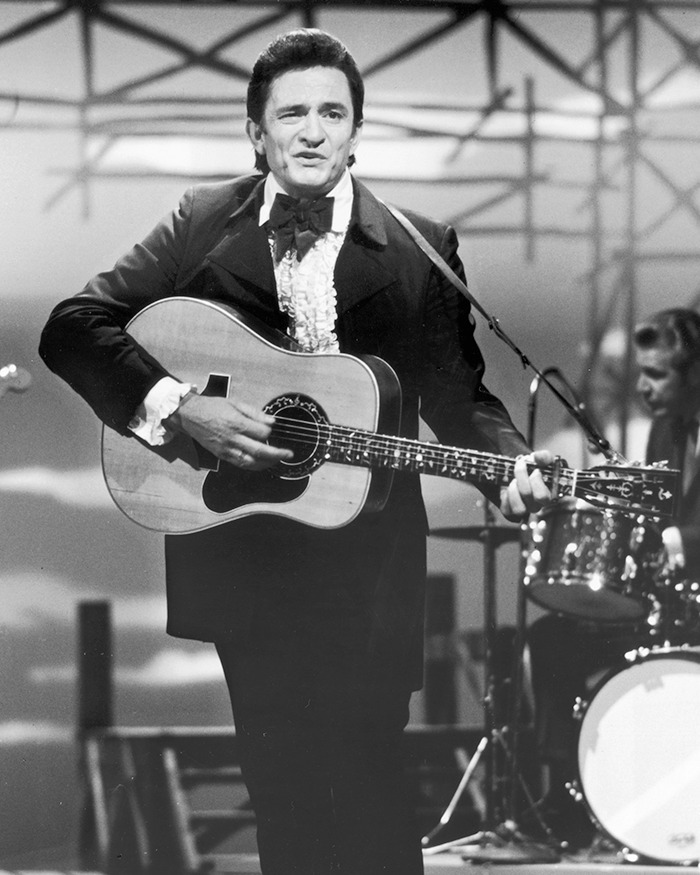 Musician playing guitar on stage, symbolizing a forgotten Hollywood scandal.