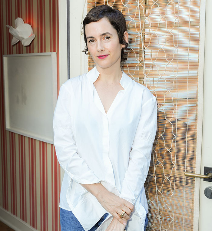 Person in casual white shirt poses, revealing behind-the-scenes insights from red carpet experiences.