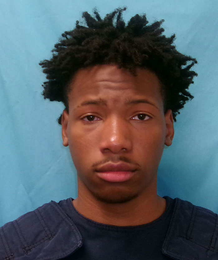 I don't know who this person is. Young man with short hair in a blue shirt, set against a light blue background.