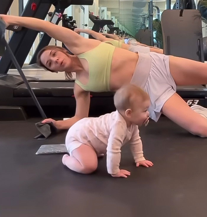 Influencer exercising with her child nearby in a gym setting.