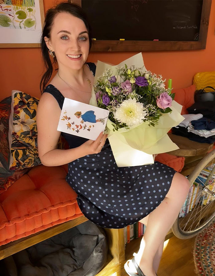 Harry Potter star smiling with flowers, holding a card, seated in a cozy room, following recent JK Rowling-related news. Harry Potter star smiling with flowers, holding a card, seated in a cozy room, following recent JK Rowling-related news.