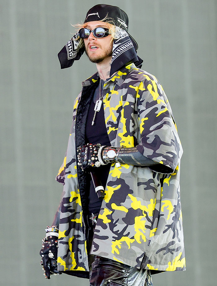 Celebrity in vibrant camo outfit and sunglasses at Coachella 2025, featured in worst dressed list.