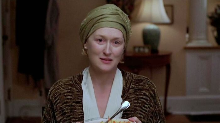 A woman in a headscarf holding a bowl, in a scene from a tear-jerking movie.