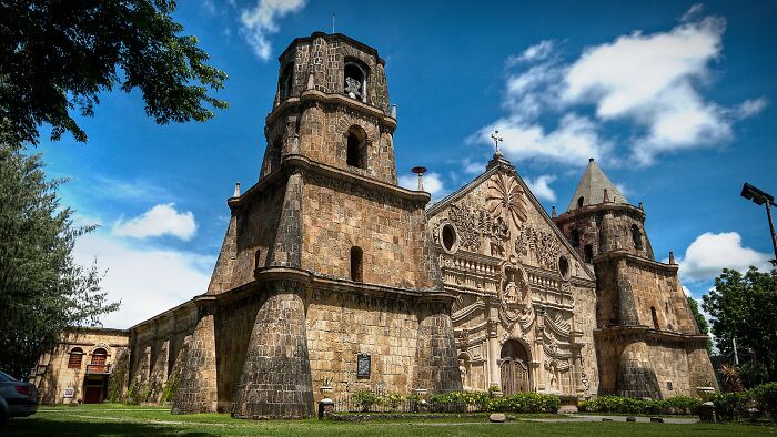 Historic architectural wonder featuring intricate stone facade and towering bell towers under a blue sky.